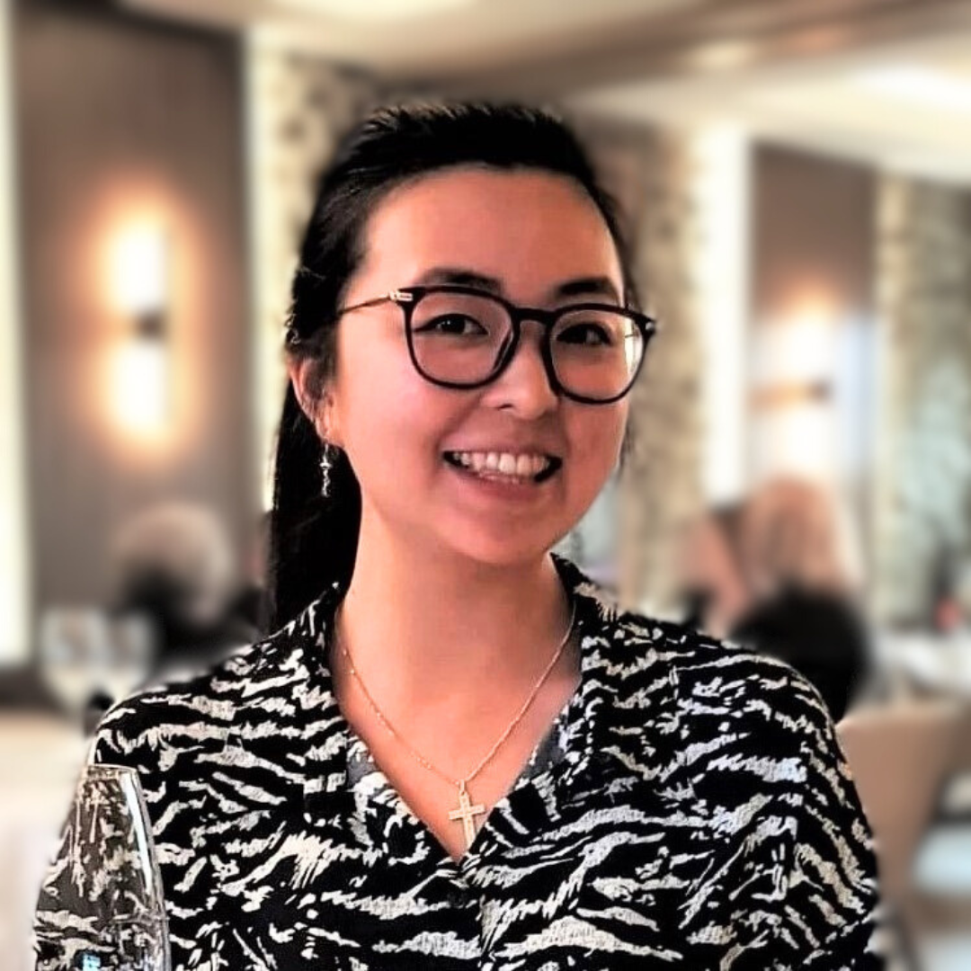 Kristen smiling and seated at a restaurant with a blurred background